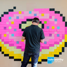 Load image into Gallery viewer, Man making post it note mural of giant pixel art donut