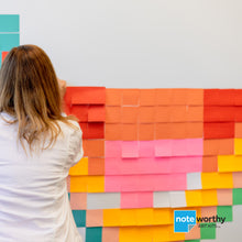 Load image into Gallery viewer, woman building post it note pixel art mural on wall